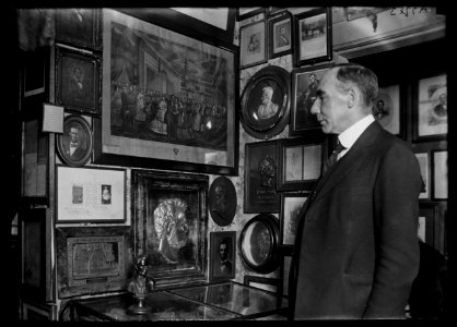Man looking at collection of Lincoln pictures LCCN2016887094