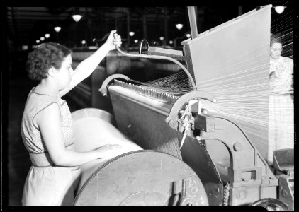 Manchester, New Hampshire - Textiles. Pacific Mills. Barber-Colman High Speed Warper. From front, Operator in act of... - NARA - 518753