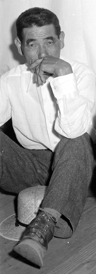 Man sitting on barracks floor, Manzanar Relocation Center, Manzanar, California. A typical interior scene in one of the barrack ap . . . - NARA - 538136 (cropped)