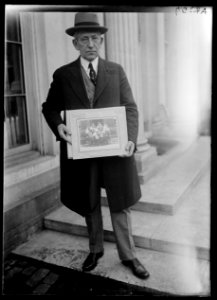 Man with photograph at White House, Washington, D.C. LCCN2016886984
