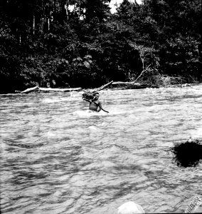 Man bär en av expeditionens bördor över den strida floden. Rio Yahuarmayo, Sydamerika. Peru - SMVK - 002493 photo