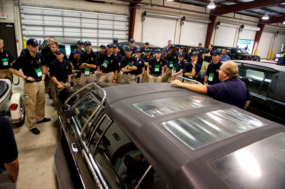 Man leans on car while addressing law enforcement explorers