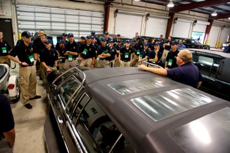 Man leans on car while addressing law enforcement explorers