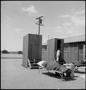 Manzanar Relocation Center, Manzanar, California. Hospital latrines, for patients, between the barr . . . - NARA - 538149