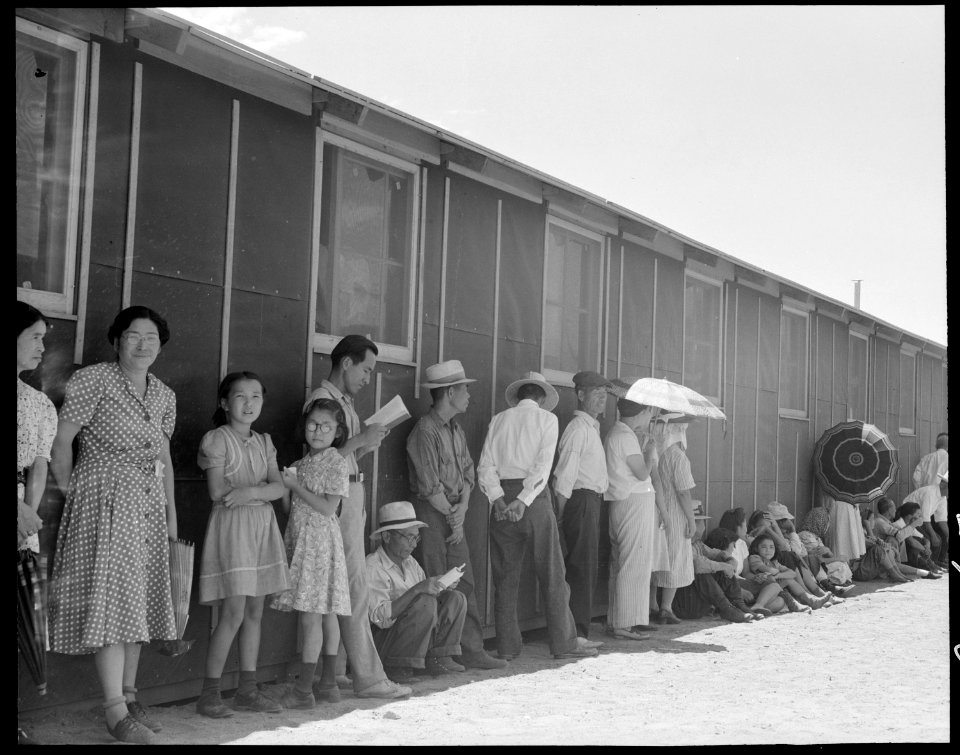 Manzanar Relocation Center, Manzanar, California. Part of a line waiting for lunch outside the mess . . . - NARA - 537968
