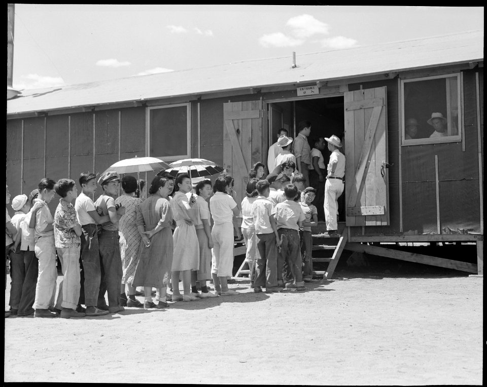 Manzanar Relocation Center, Manzanar, California. Part of a line waiting for lunch outside the mess . . . - NARA - 537967