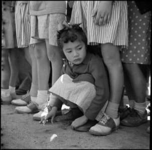 Manzanar Relocation Center, Manzanar, California. A little girl evacuee of Japanese descent watches . . . - NARA - 538550