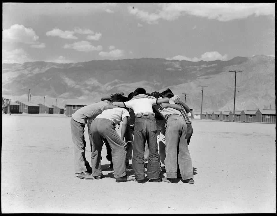Manzanar Relocation Center, Manzanar, California. Baseball players in a huddle. This game is very . . . - NARA - 538066