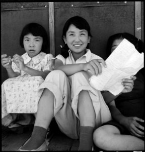 Manzanar Relocation Center, Manzanar, California. Young evacuee girls gather in the shade of their . . . - NARA - 538088