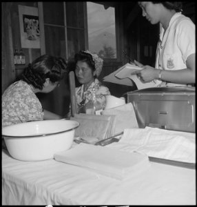Manzanar Relocation Center, Manzanar, California. Young expectant mother (center) receives check-up . . . - NARA - 538142