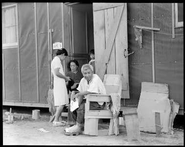 Manzanar Relocation Center, Manzanar, California. Evacuees family of Japanese ancestry relax in fro . . . - NARA - 537990