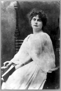 Marie Corelli, three-quarter length portrait, seated, holding book, facing front LCCN89706402