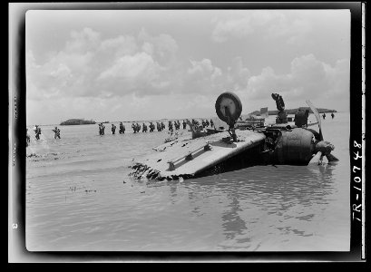 Marines move past wrecked Jap dive bomber on way to Agat beach on Guam. - NARA - 520965