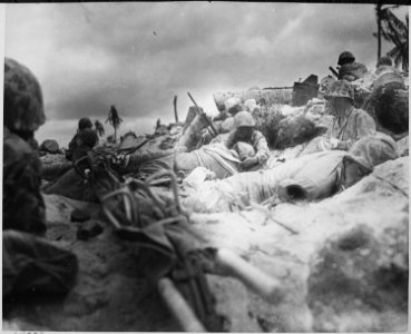 Marines take cover behind a sea wall on Red Beach ^3, Tarawa. - NARA - 532385