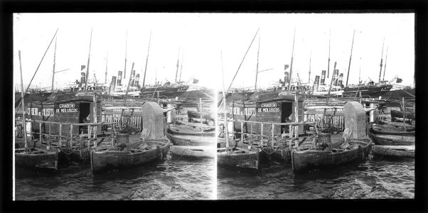 Moll amb barques i un viver de mol·luscs , al fons alguns vaixells