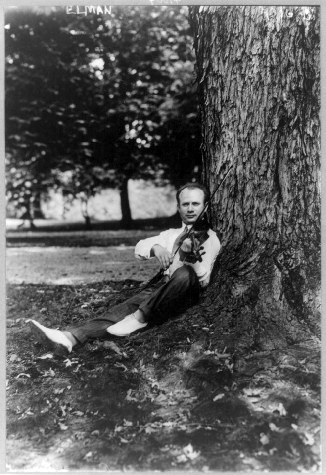 Mischa Elman, 1891-1967, sitting against tree, playing violin LCCN2005687497