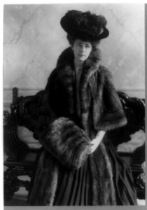 Miss A. L. Ide, three-quarter-length portrait, standing, facing right, wearing fur coat, plumed hat and muff LCCN91481430