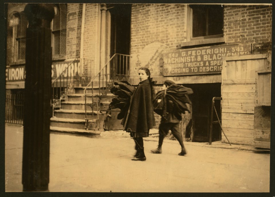 Nine and twelve-year-old children carrying coats home to be finished. Thompson St., N.Y. LOC nclc.04181