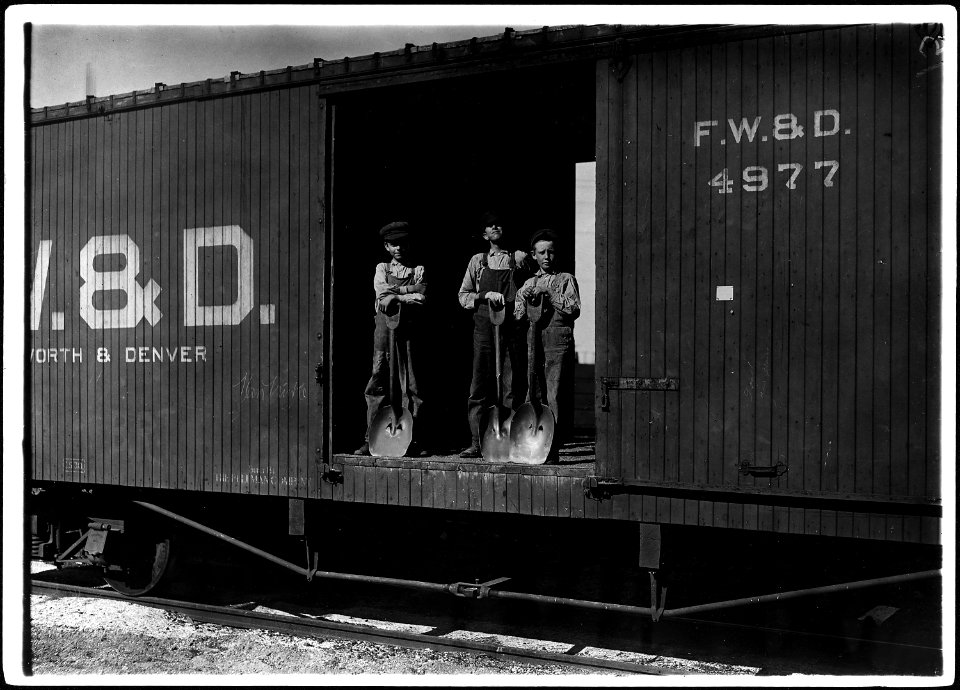 No caption. Three young boys with shovels standing in doorway of a Fort Worth & Denver train car. - NARA - 523335