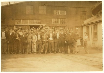 Noon-hour. Cumberland Glass Works, Brigeton(sic), N.J. Smallest boy in middle of front row and one on right-hand end have been in this pant four years. See also photos -957 to 971. LOC nclc.01212