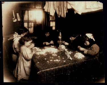 Mortaria family, 8 Downing St., N.Y., making flowers wreaths. The Little three-year-old on left was actually helping, putting the center of the flower into the petal, and the family said she LOC cph.3a01154
