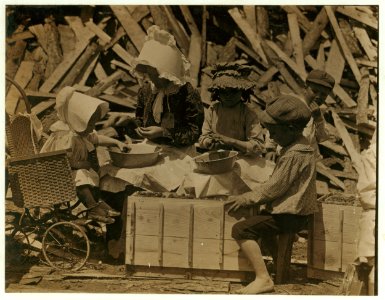 Mother and children hulling strawberries at Johnson's Hulling Station. Cyral (in baby cart) is 2 yrs. old this May and works steadily hulling berries. At times Cyral would rest his little LOC nclc.05326