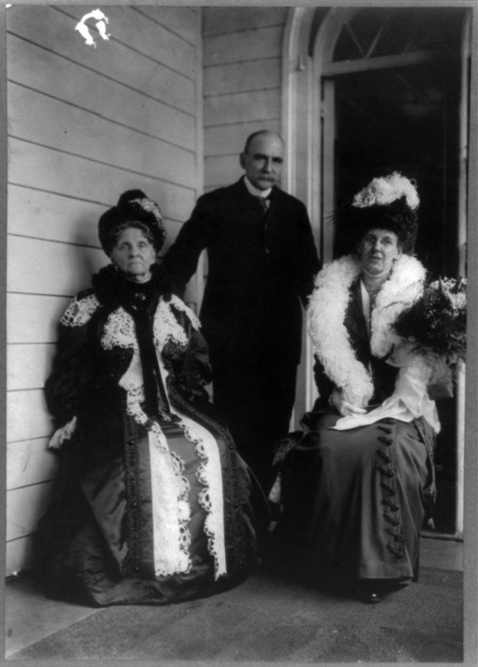 Matthew Astor standing on porch behind his wife and Hetty Green LCCN2002715419