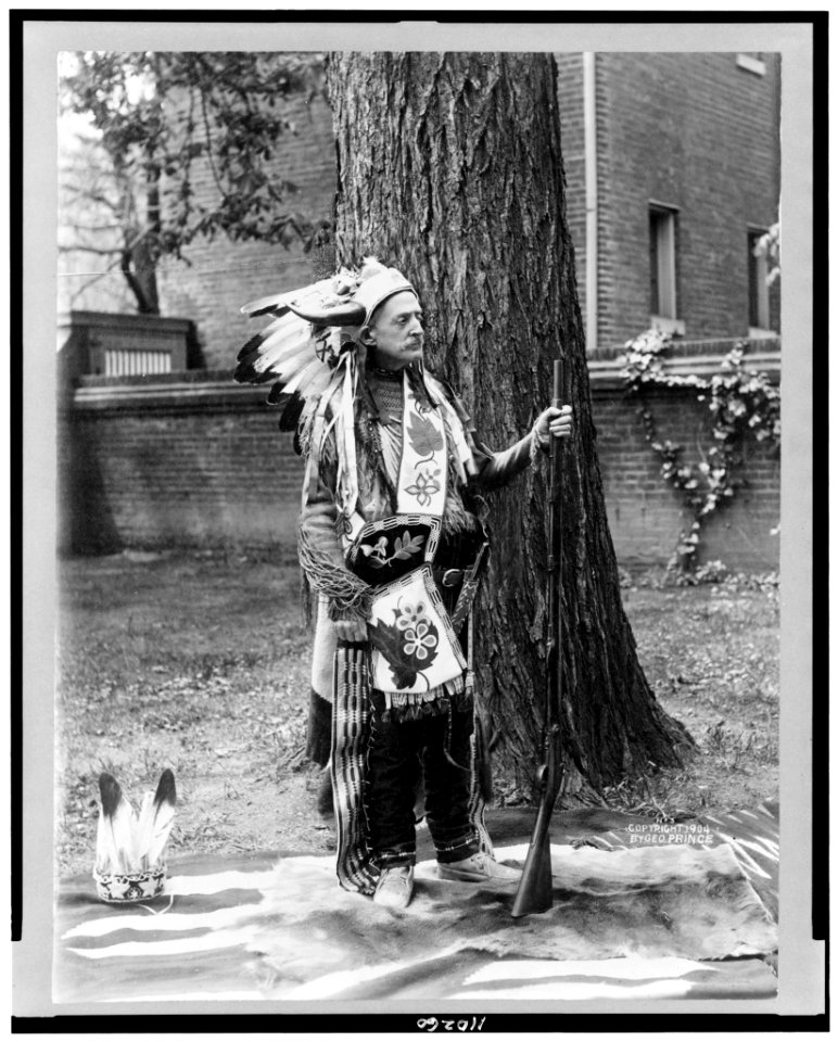 Matthew Stanley Quay, full-length portrait, standing, facing right, dressed in Indian costume, holding rifle LCCN94502619