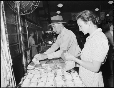 Mr. and Mrs. Blaine Sergent shop for children's socks in Harlan, Kentucky., on Saturday afternoon. Harlan, Harlan... - NARA - 541315