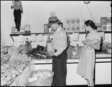 Mr. and Mrs. Blaine Sergent shopping for groceries in Harlan on Saturday afternoon. They buy most of their supplies... - NARA - 541322
