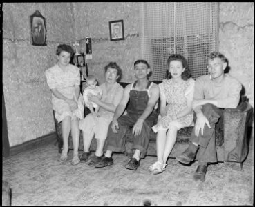 Mr. and Mrs. Theo Sizemore, their son and two daughters-in-law and grandchild in the living room of their four room... - NARA - 541202