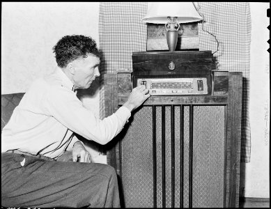 Mr. Sergent dresses in clean clothing early in the morning, turns on the radio for some music to start the day... - NARA - 541351
