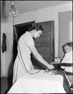 Mrs. Blaine (Rhoda) Sergent, pressing her husband's trousers, this was on Friday afternoon and it is customary for... - NARA - 541287