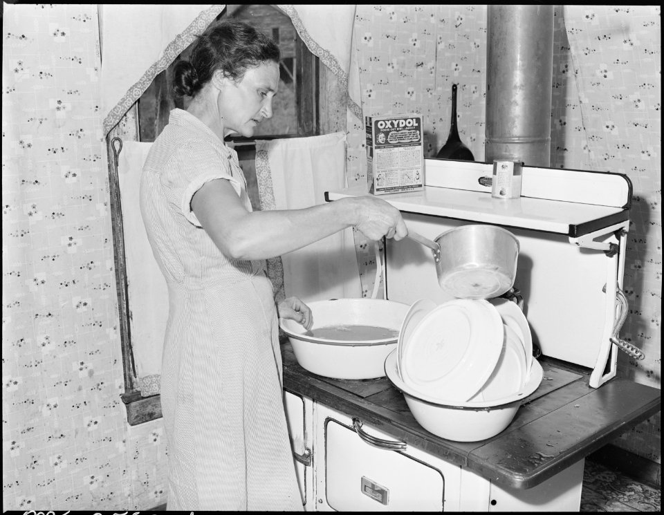 Mrs. Blaine Sergent rinsing the freshly washed breakfast dishes. P V & K Coal Company, Clover Gap Mine, Lejunior... - NARA - 541309