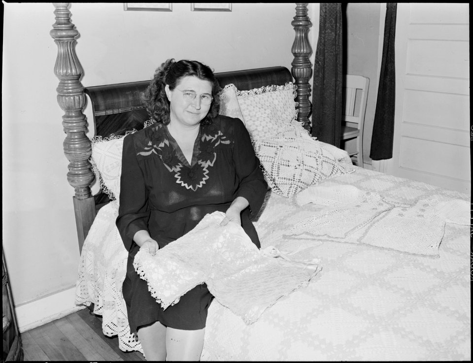 Mrs. C. Elkins, wife of coal miner, surrounded by some of her crocheted work, for which she has won many awards.... - NARA - 541461