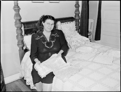 Mrs. C. Elkins, wife of coal miner, surrounded by some of her crocheted work, for which she has won many awards.... - NARA - 541461