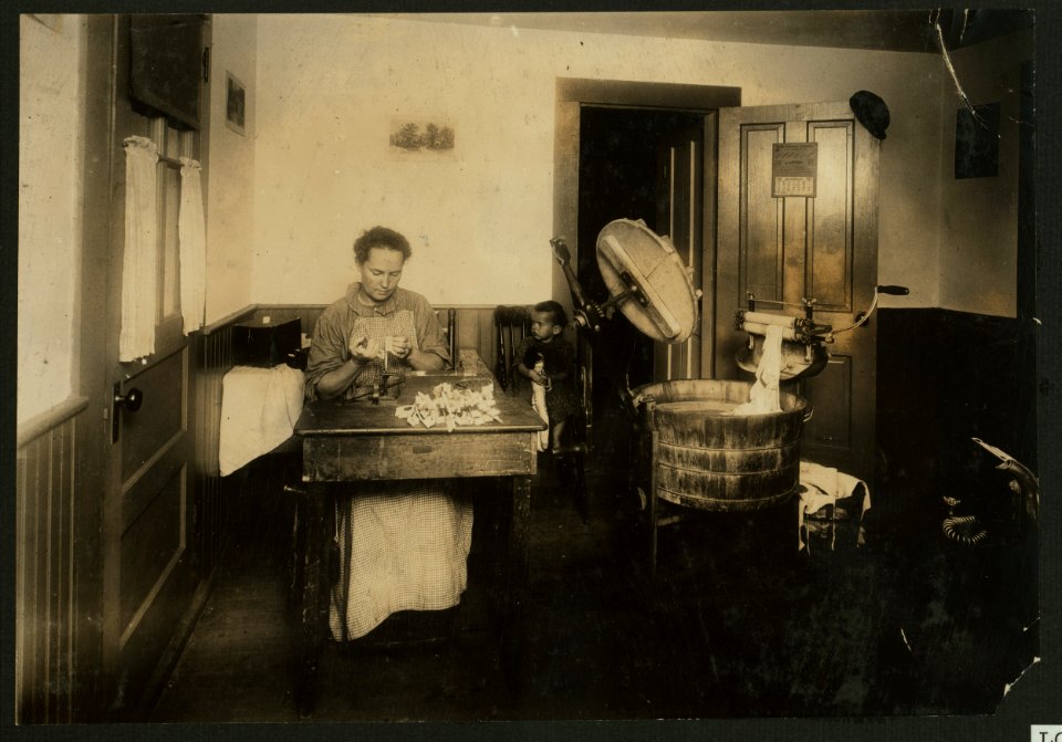 Mrs. Eugene Lampron, Reservoir Street, Leeds, Mass., putting the bristles into tooth brushes in the kitchen of her home. She has been doing it for 9 years, and showed the effect of it. See LOC nclc.04261