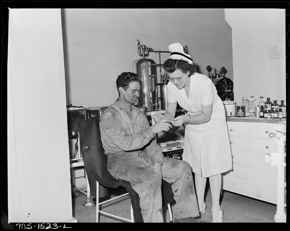 Mrs. Eva Ruth Gray, RN., with patient in the operating room at the Gary hospital. There are three treatment rooms... - NARA - 540838