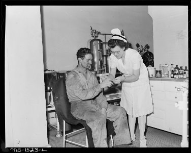 Mrs. Eva Ruth Gray, RN., with patient in the operating room at the Gary hospital. There are three treatment rooms... - NARA - 540838