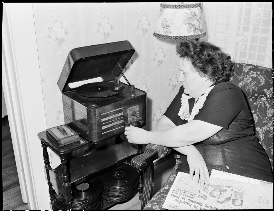 Mrs. Harry Fain, coal loader's wife, relaxes after work in the grocery store at Wheelwright Junction. Inland Steel... - NARA - 541508