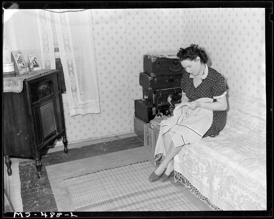 Mrs. Dan Marques, wife of miner, living in company housing project, does some sewing in one of the bedrooms of their... - NARA - 540442