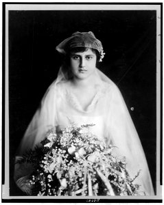 Mrs. Henry Morgenthau, née Elinor Fatman, half-length portrait, facing front, in bridal gown, holding large bouquet LCCN97510082