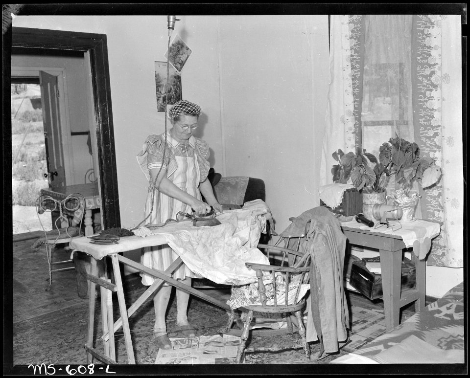 Mrs. Irving Bittick, ironing in living room of her home in company housing project. Independent Coal & Coke Company... - NARA - 540522