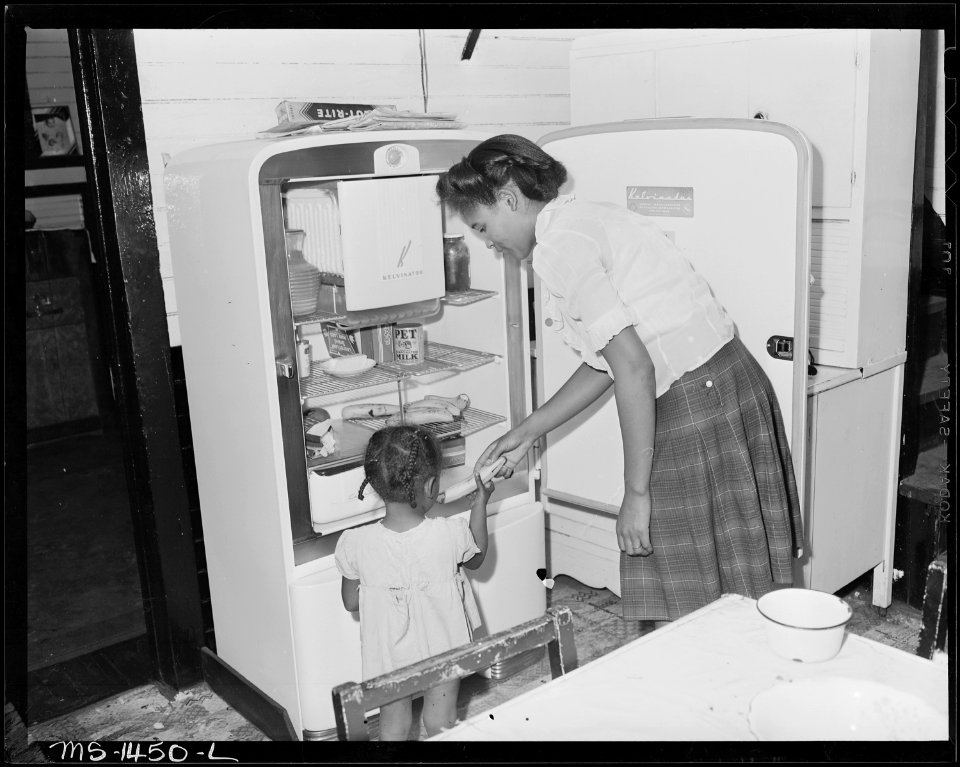 Mrs. James Robert Howard gives her daughter a banana from electrical refrigerator. The Howard bill for electricity is... - NARA - 540800