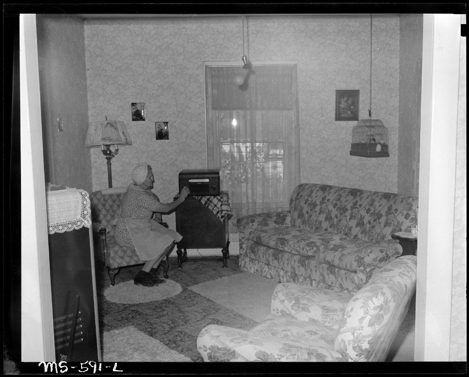 Mrs. Jessie Manchester, wife of miner, living in company housing project, turning on the radio. Independent Coal &... - NARA - 540510