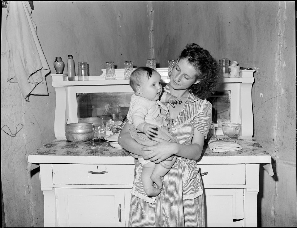 Mrs. Lincoln Hagg with her baby in the kitchen of her house. Panther Red Ash Coal Corporation, Douglas Mine, Panther... - NARA - 540995