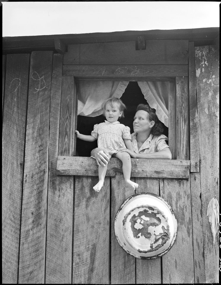 Mrs. Leanore Miller, widow of a miner, with one of her children at her kitchen window. Kentucky Straight Creek Coal... - NARA - 541273