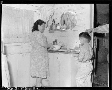 Mrs. Manuel Alcala and son in corner of their kitchen. The family lives in company housing project for miners.... - NARA - 540462
