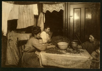 Mrs. Mary Rena, 46 Laight St., 3d floor front, picking nuts with dirty baby in lap. Two neighbors helping. Girl is cracking nuts with her teeth, not an uncommon sight. Mr. Rena works on LOC cph.3b01098