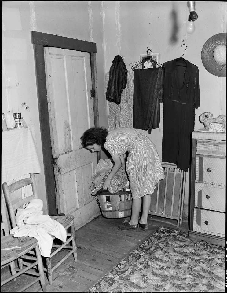 Mrs. Lincoln Hagg, wife of miner, in the bedroom of her house. This house is estimated to be at least forty years... - NARA - 540994